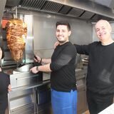 Achilleas Tzakos (M.), sein Vater Theofanis Tzakos und Mutter Eftischia Tsepi stehen am Gyros-Spieß im „Achillion-Grill“ an der Hochstraße in Waltrop.