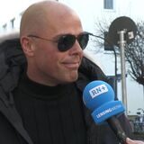 Ein Mann mit einer Sonnenbrille spricht bei einer Umfrage in ein Mikrofon mit RN-Logo