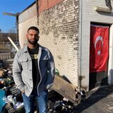 Vijay Raj, Geschäftsführer des Ani-Marktes in Lenkerbeck, steht vor den Resten der verbrannten Hilfsgüter. Im Hintergrund hängt wieder eine türkische Flagge.