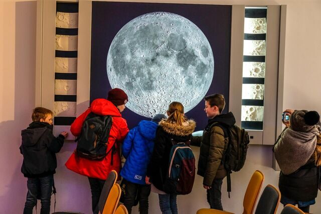 Kinder vor einem Bild vom Mond in der Sternwarte in Recklinghausen.