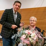 Bürgermeister Werner Arndt überreicht Marlene Sagasser einen Blumenstrauß und einen Sticker der Stadt.