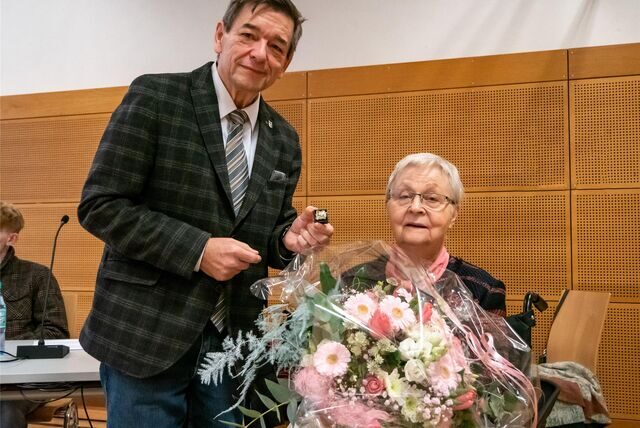 Bürgermeister Werner Arndt überreicht Marlene Sagasser einen Blumenstrauß und einen Sticker der Stadt.