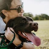 Eine Frau hält einen Hund im Arm.