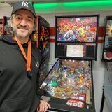 Parviz Ghavami steht vor einem Flipperautomaten.