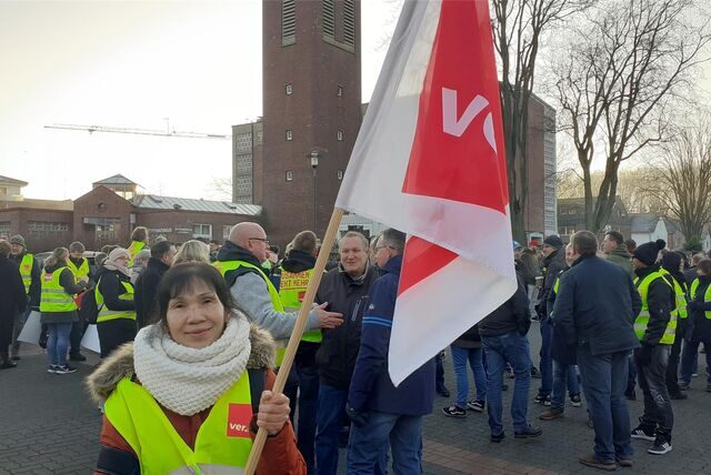 Eine Frau trägt eine Fahne.
