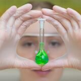 Symbolbild, eine Schülerin hält ein Reagenzglas mit grüner Flüssigkeit vor ihr Gesicht. Der Chemie- und Physikunterricht an Oer-Erkenschwicker Schulen wurde Anfang 2013 auf ein deutlich moderneres Level gehoben.