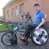 Der Waltroper Lucas Klink sitzt in seinem Rollstuhl, vor den er das Speedy-Bike spannt. Das Spezialgefährt ist jetzt demoliert.