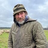 Erwin Biedermann steht auf einer Wiese in Rhade. Hinter ihm ist seine Schafherde.