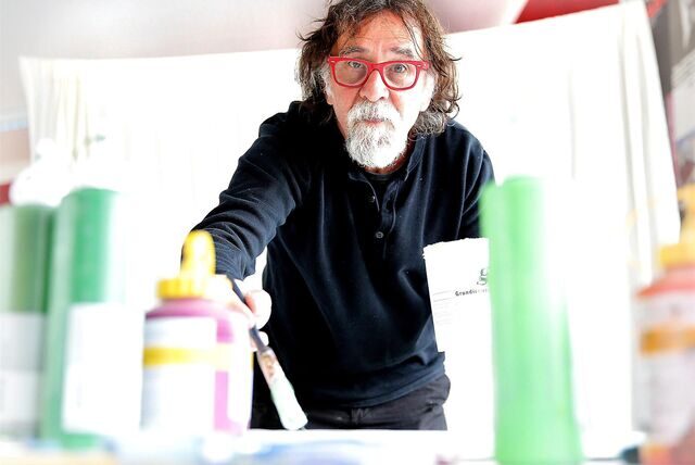 Der Stadtmaler 2013 in Waltrop, Tamer Serbay, steht mit Pinsel und Farben in einem Raum an der Gesamtschule.