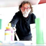 Der Stadtmaler 2013 in Waltrop, Tamer Serbay, steht mit Pinsel und Farben in einem Raum an der Gesamtschule.