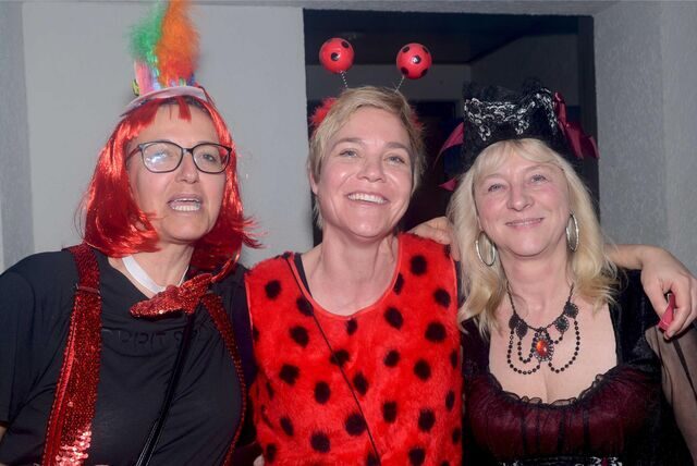 Drei Frauen in bunten Kostümen bei der Karnevalsfeier der 4. Waltroper Kompanie.