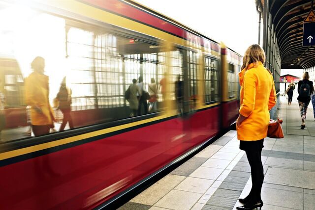 frau wartet auf die bahn am gleis