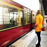 frau wartet auf die bahn am gleis