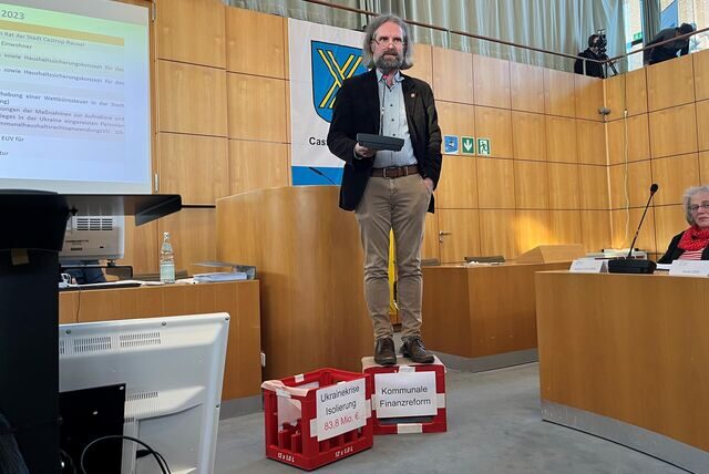 Daniel Molloisch seht im Ratssaal auf zwei Cola-Kisten.