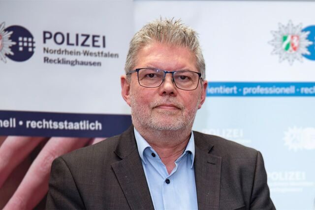Didi Jünemann liest aus vor einer Leinwand aus einem Buch.