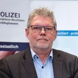 Didi Jünemann liest aus vor einer Leinwand aus einem Buch.