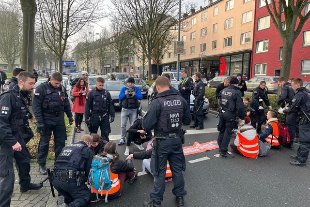 Polizisten lösen eine Sitzblockade auf der Ruhrallee in Dortmund auf.
