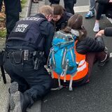 Polizisten lösen eine Sitzblockade auf der Ruhrallee in Dortmund auf.
