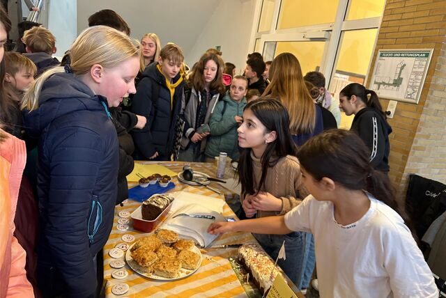 Schüler verkaufen in der Pause Kuchen für eine Spendenaktion.