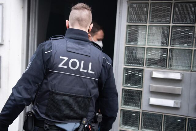 Ein Mann vom Zoll geht in ein Haus.