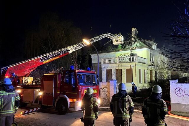 Feuerwehrleute und eine Drehleiter stehen während eines Einsatzes vor einem Haus an der Nahestraße in Recklinghausen