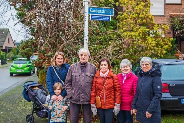 Anwohner stehen unter einem Straßenschild.