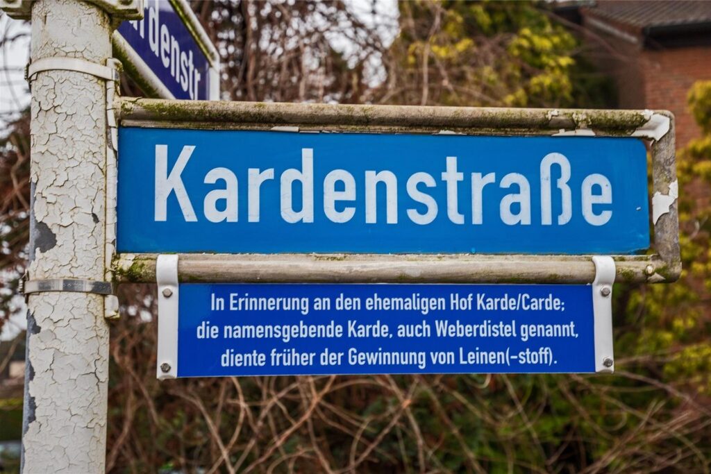 Ein Straßenschild weist auf die Herkunft des Namens Kardenstraße hin.