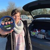 Jennifer Hecht steht am Straßenrand der Wartburger Straße und hält ein Ciplesegerät in die Kamera.