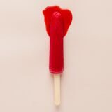 Ein stilisierter Tampon liegt mit roter Farbe getränkt auf beigem Grund.