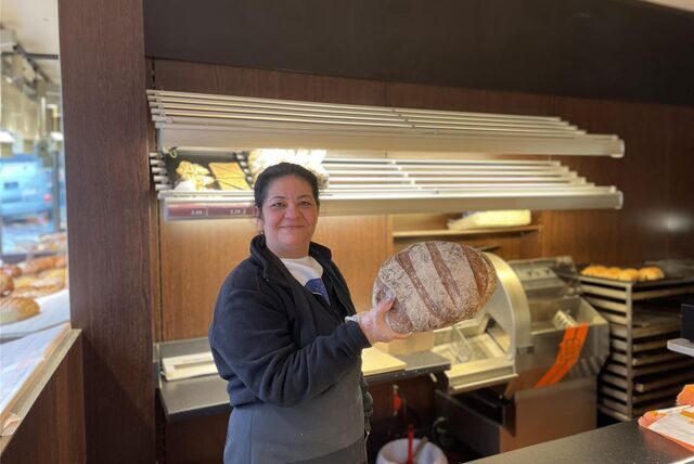 Kaya Handan steht mit einem frischen Brot hinter der Theke der Bäckerei Schickentanz in der Castroper Innenstadt.