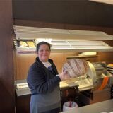 Kaya Handan steht mit einem frischen Brot hinter der Theke der Bäckerei Schickentanz in der Castroper Innenstadt.