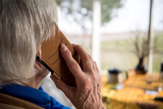 Eine ältere Frau hat ein Telefon am Ohr. Falsche Polizisten oder Verwandte können gefährlich sein: Oft steckt ein Betrugsversuch dahinter.