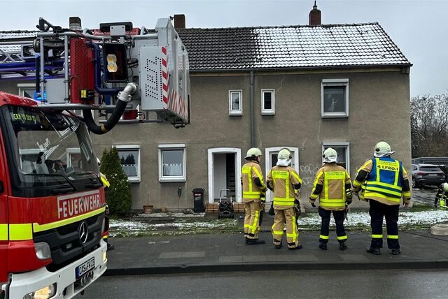 Feuerwehrleute stehen vor einem Haus an der Borghagener Straße.