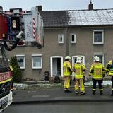 Feuerwehrleute stehen vor einem Haus an der Borghagener Straße.