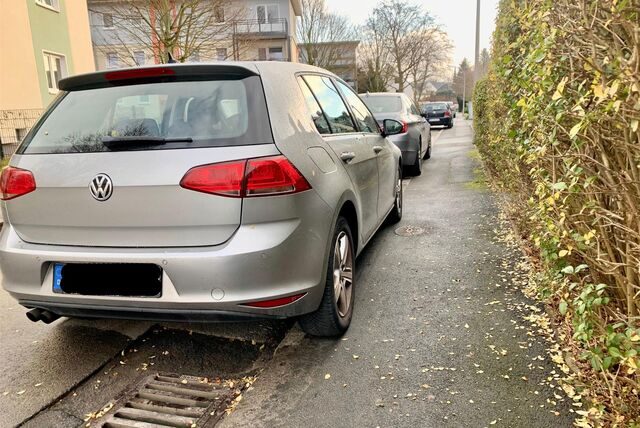 Ein Auto parkt mit zwei Reifen auf dem Gehweg.