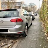 Ein Auto parkt mit zwei Reifen auf dem Gehweg.