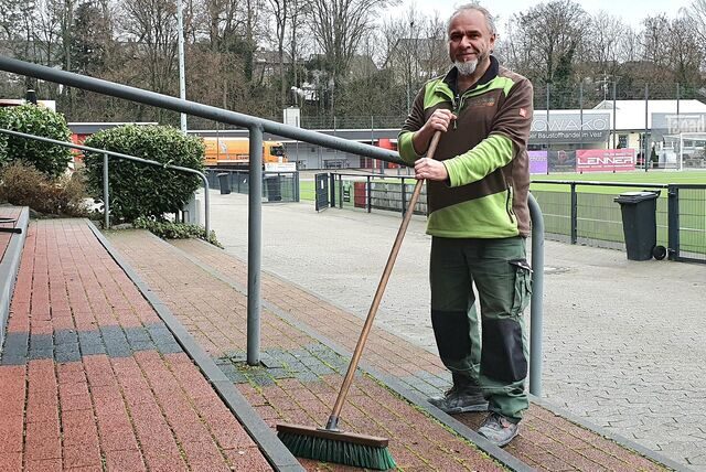 Andre Oberlin steht mit einem Besen auf der Tribüne der Vorplätze des Stimbergstadions.