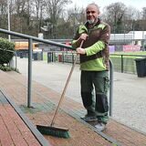 Andre Oberlin steht mit einem Besen auf der Tribüne der Vorplätze des Stimbergstadions.
