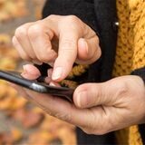 Eine Person hält ein Smartphone in der Hand.