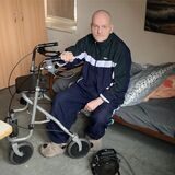 Mike Feigl sitzt in seinem Zimmer in der Notunterkunft für Obdachlose in Marl auf seinem Bett.