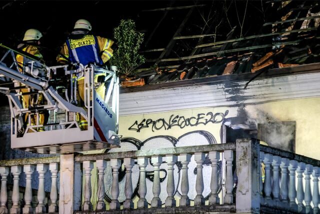 Feuerwehrleute im Drehleiterkorb vor der Brandruine des ehemaligen Bordellbetriebs an der Nahestraße in Recklinghausen