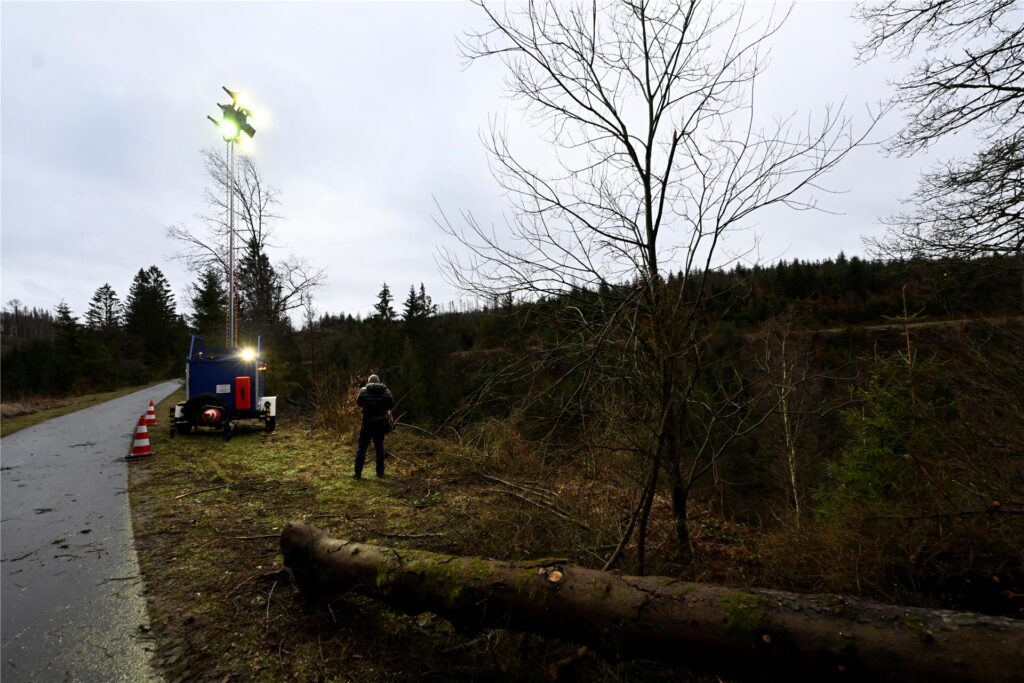 Ein Scheinwerfer des Technischen Hilfswerks (THW) Siegen steht in einem Waldstück, in dem gestern die Leiche eines 12-jährigen Mädchens gefunden worden ist.
