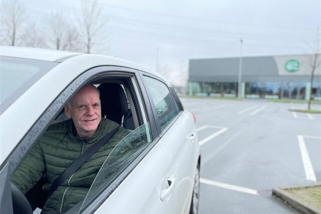 Ein Mann sitzt in seinem Auto auf dem Globus-Parkplatz, wo ein Trödelmarkt ausgefallen ist.