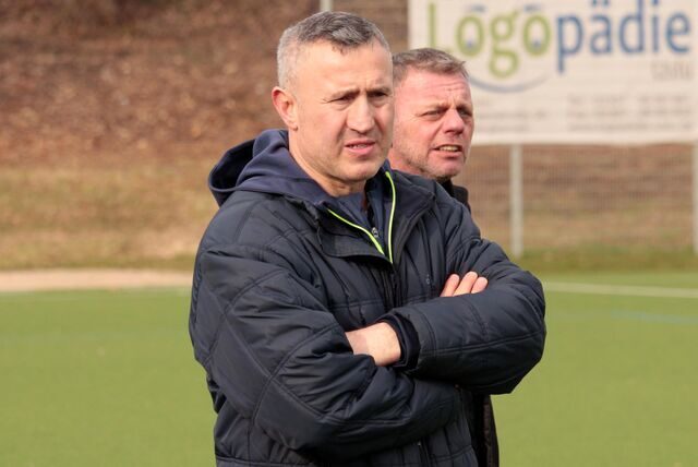 Trainer Ahmet Kahya (hier vor seinem Co-Trainer Torsten Lenz) steht mit verschränkten Armen am Spielfeldrand.