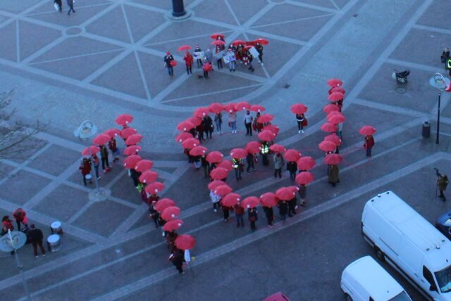 Mit roten Schirmen formen die Menschen „18 %“ auf dem Dortmunder Friedensplatz.
(Archiv)