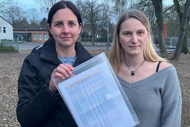 Eva Prost (links) und Saskia Schoof zeigen die lange Liste mit eingeschränkten Betreuungszeiten an der Kita „Schatzkiste“ in Opherdicke. Die beiden Mütter berichten von einer massiven Belastung.