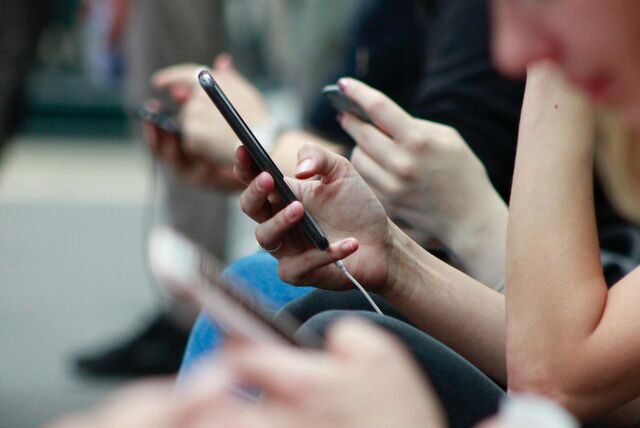 Eine Person hat ein Handy in der Hand und tippt darauf herum.