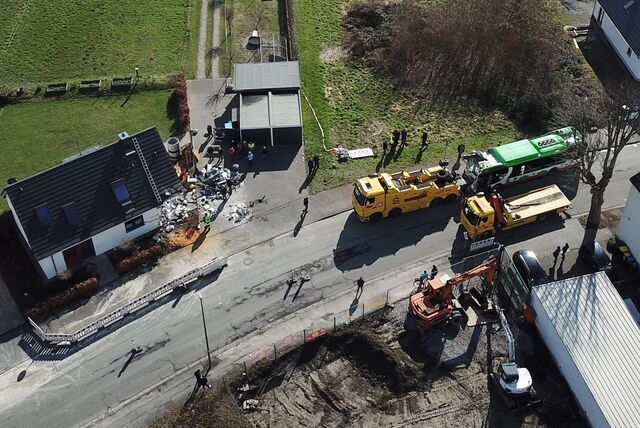 Vor der zertrümmerten Hausecke liegen Splitter und Teile von Bus und Haus. Der Elektrobus der HCR hängt an der Abschlepp-Vorrichtung eines 580-PS-Spezielabschleppers.