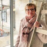 Annette Lamprecht, Bauherrin der neuen Deilmann-Passage in Datteln, steht an einer Leiter im Rohbau des Hauses.