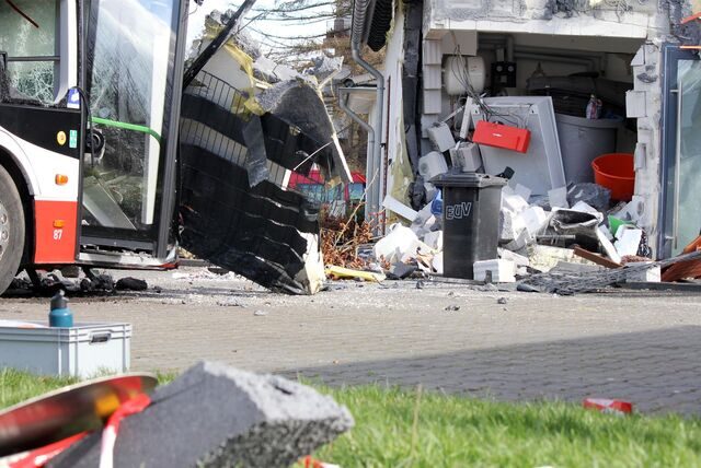 Der Elektrobus ist schwer demoliert, hat noch den Zaun des Hauses auf seiner Front. Im Haus von 2017 klafft ein großes Loch nach dem Busunglück von Castrop-Rauxel am Montag.